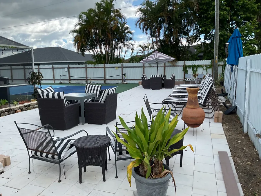 Courtyard with tables, striped cushions and plants next to the court